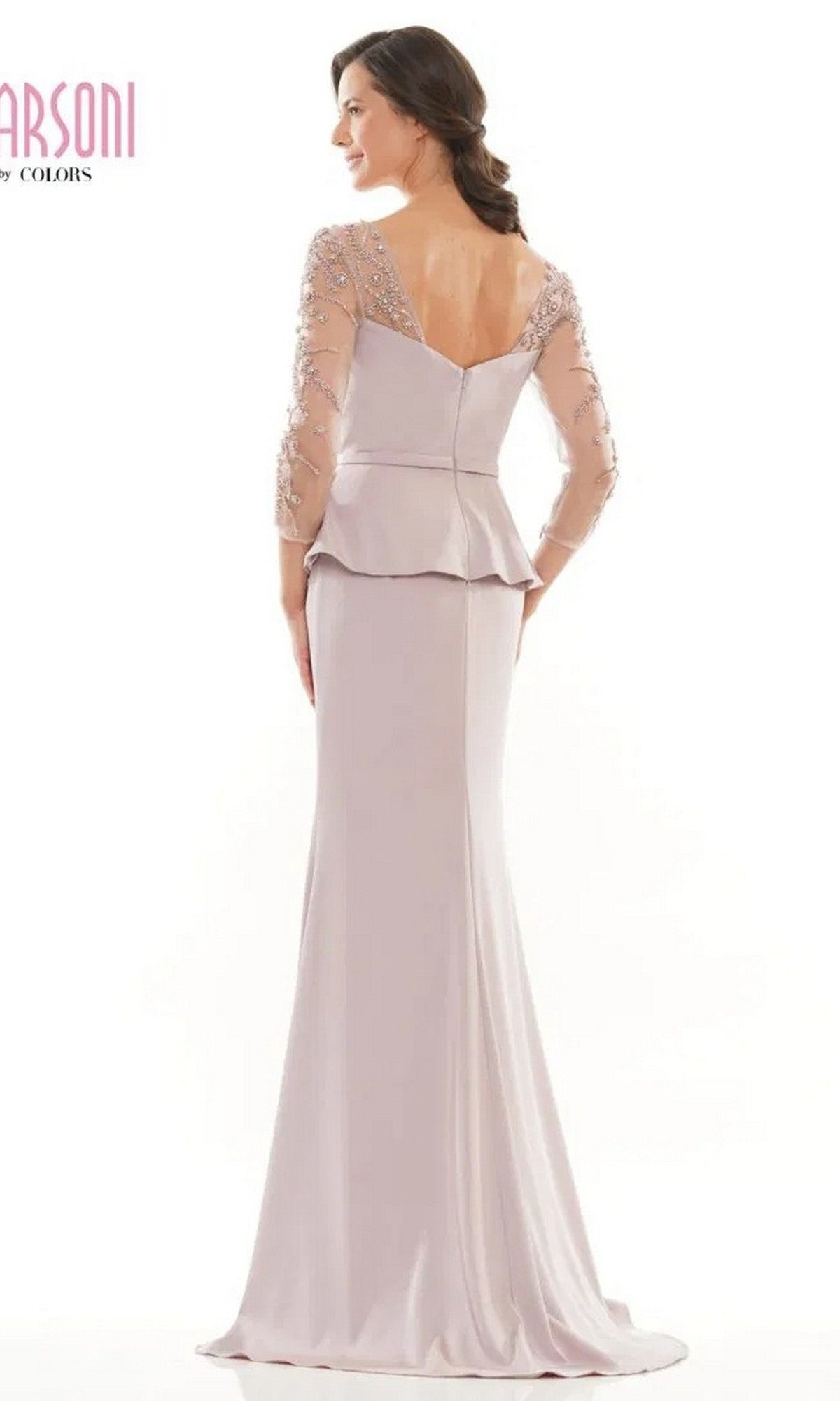A woman wearing the Marsoni MV1037—a long formal dress in light lavender with sheer beaded sleeves, peplum waist, and V-shaped back—stands facing away.
